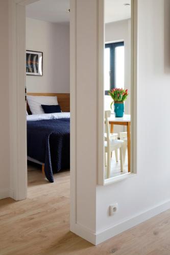 a bedroom with a bed and a table with a mirror at Office Park Aparthotel in Toruń