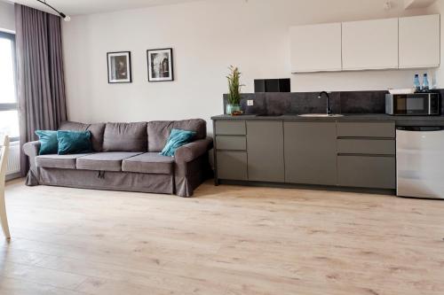 a living room with a couch and a kitchen at Office Park Aparthotel in Toruń