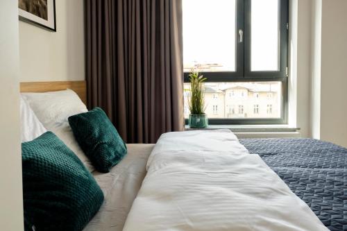a large bed in a room with a window at Office Park Aparthotel in Toruń