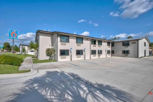 un gran edificio blanco con aparcamiento en Motel 6-Fort Lauderdale, FL, en Fort Lauderdale