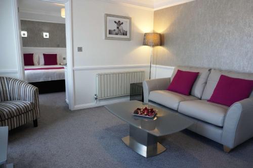 a living room with a couch and a table at Best Western Royal Hotel in Saint Helier Jersey