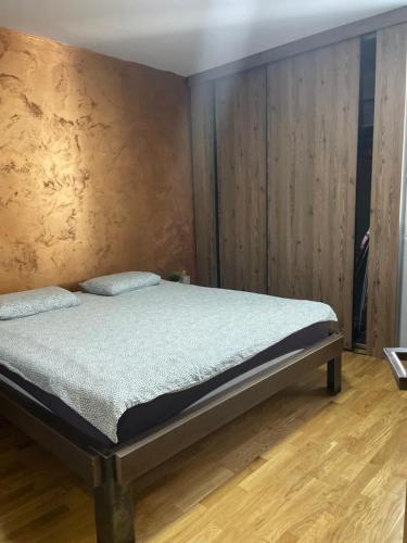 een slaapkamer met een bed en een houten vloer bij Industrial magic on Pedestian zone in Skopje