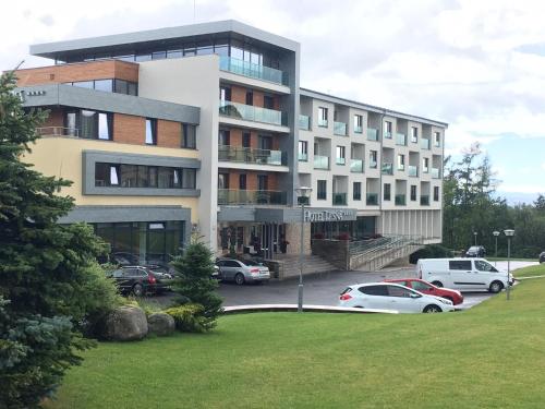 a large building with cars parked in a parking lot at PRIVILEGED LESNÁ - with Garden Terrace, Tatranská Lomnica 2 km in Tatranská Lomnica