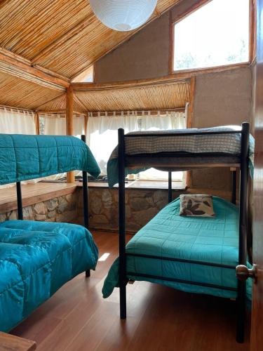 a room with two bunk beds and a window at Cabañas Luna de Cuarzo, Cochiguaz in Paihuano