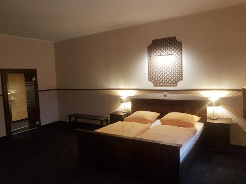 a bedroom with two beds and two lights on the wall at Gotikhotel Frenzelhof in Görlitz