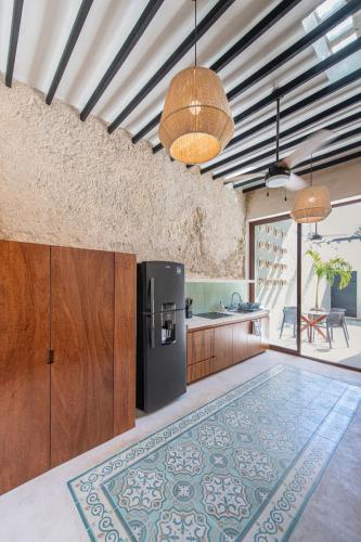 an open kitchen with a refrigerator and a counter at Casa Bolero Santa Lucía with Parking by Cercana in Mérida