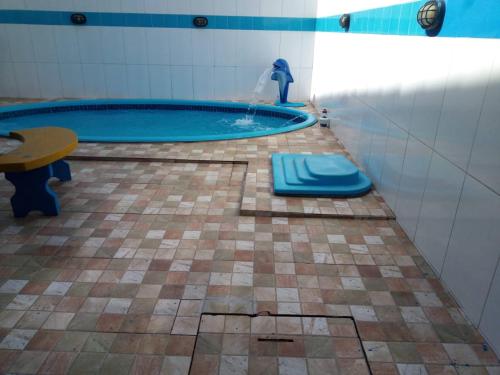 uma casa de banho com uma piscina com uma mesa e uma fonte em Aconchego em Maragogi