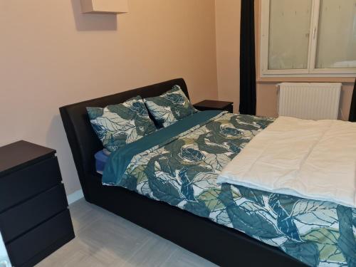 a bedroom with a bed with a comforter and pillows at Appartement t2 calme spacieux Saint-Étienne bellevue in Saint Etienne