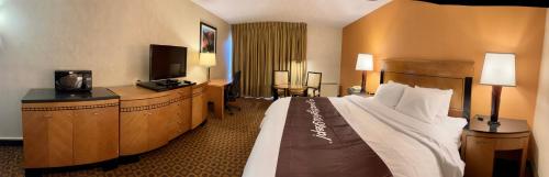 a hotel room with a large bed and a television at Bradley Inn in Windsor Locks