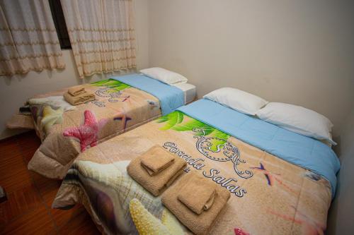 two beds with towels on them in a room at POSADA SALAS & KARI PERU TRAVEL in Mollendo