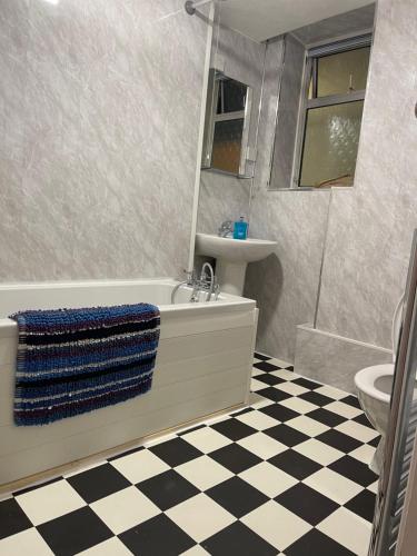 a bathroom with a tub and a sink and a toilet at Poolside in Peacehaven