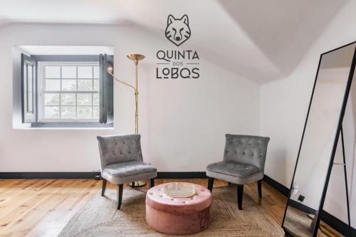 two chairs and a table in a room with a sign at Quinta dos Lobos Boutique Hotel - Nature Experience in Sintra