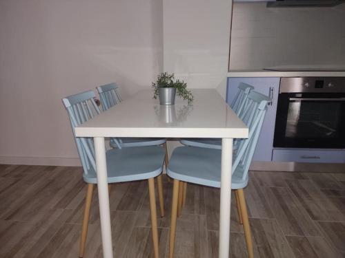 een keuken met een tafel en twee blauwe stoelen bij Central Comfy Appartment in Agrinion
