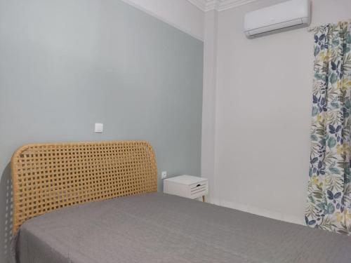 een slaapkamer met een rieten bed en een raam bij Central Comfy Appartment in Agrinion
