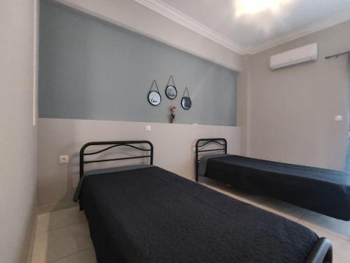 een slaapkamer met 2 bedden en een muur met 2 spiegels bij Central Comfy Appartment in Agrinion
