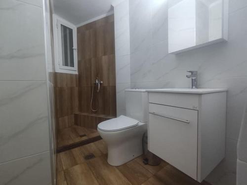 ein weißes Bad mit einem WC und einer Dusche in der Unterkunft Central Comfy Appartment in Agrinio