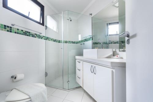 y baño con ducha acristalada y lavamanos. en Apartamento Jardins Boutique, en São Paulo