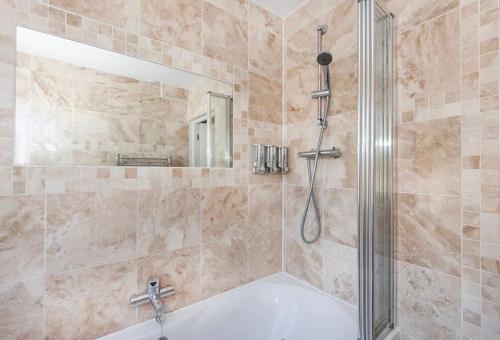 a bathroom with a shower and a white tub at Lovely one bed apartment with free parking in York