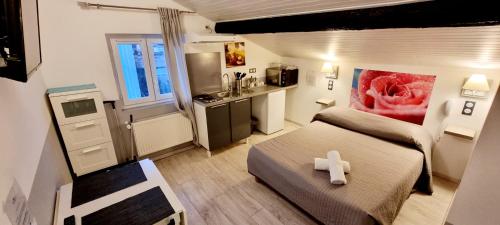 Habitación pequeña con cama con una cruz blanca. en Hôtel restaurant et pension soirée étape Bel Air en Balaruc-les-Bains