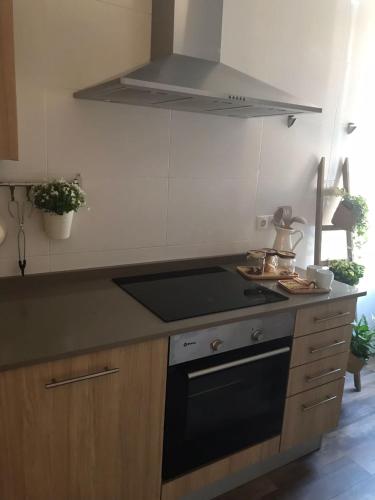 a kitchen with a stove and a stove top oven at Apartamento Palacio Valdés, centro Avilés, con parking in Avilés