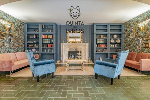 sala de estar con sillas azules y chimenea en Quinta dos Lobos Boutique Hotel - Nature Experience, en Sintra