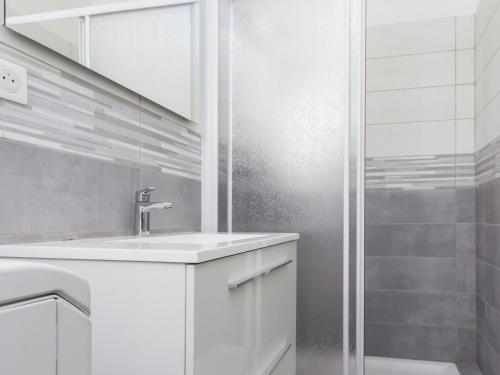 een witte badkamer met een wastafel en een douche bij Gîte Vertou, 2 pièces, 3 personnes - FR-1-306-1217 in Vertou