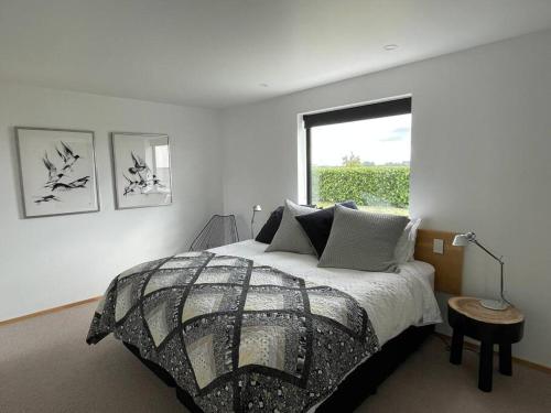 a bedroom with a large bed and a window at The Cube in Kakanui