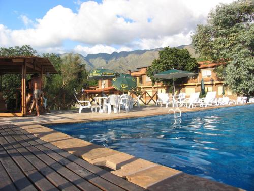 una piscina con sillas y sombrillas en un complejo en Hotel El Hornero Spa en Merlo