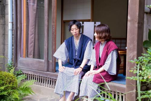 a man and a woman sitting on a bench at Ryokan Seifuso in Ōmuta