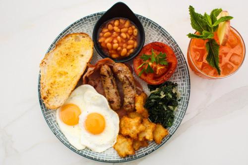 ein Frühstücksteller mit Eiern, Speck, Bohnen und Toast in der Unterkunft Crowne Plaza Residences Port Moresby, an IHG Hotel in Port Moresby