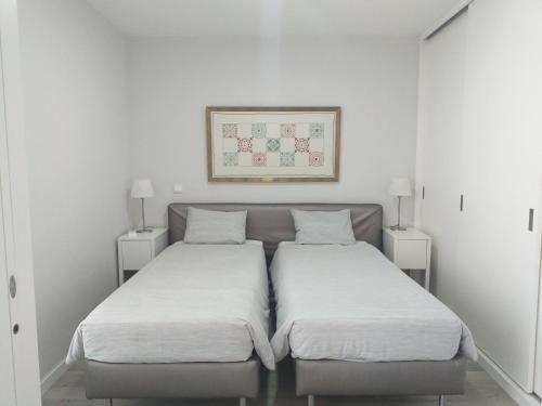 two beds in a room with white walls at H2O Porto Ribeira in Porto