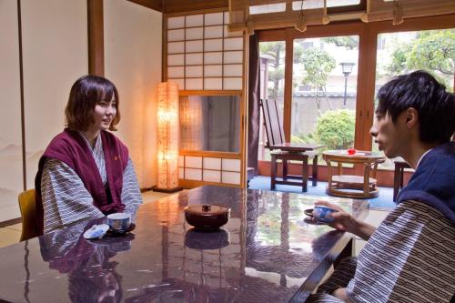 a man and a woman sitting at a table at Ryokan Seifuso in Ōmuta