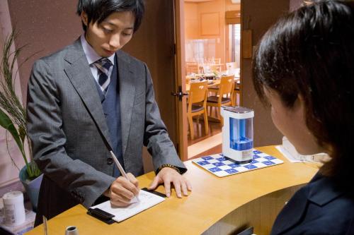a man and a woman sitting at a table at Ryokan Seifuso in Ōmuta