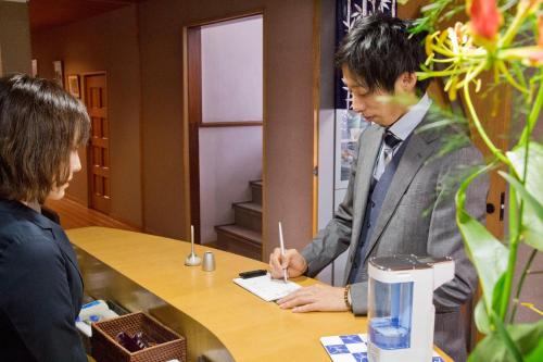 a man and a woman sitting at a table at Ryokan Seifuso in Ōmuta