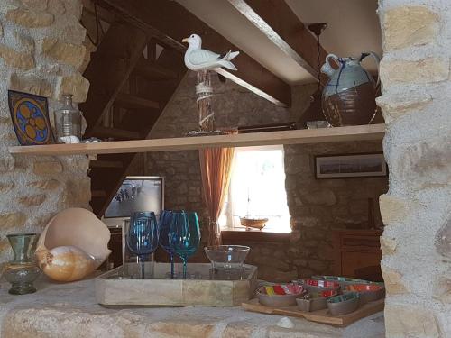 Una habitación con un estante con jarrones y un pájaro. en Breton granite stone house, Camaret-sur-Mer, en Camaret-sur-Mer