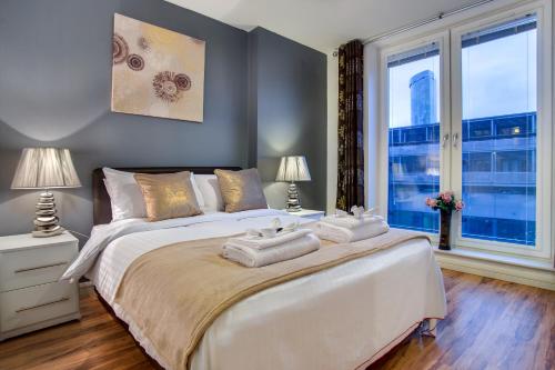 a bedroom with a large bed with two towels on it at Inners City Apartments -On Suites in Birmingham