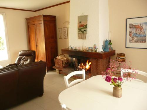 un salon avec une table et une cheminée dans l'établissement Holiday Home in Treompan near Sandy Beaches, à Ploudalmézeau