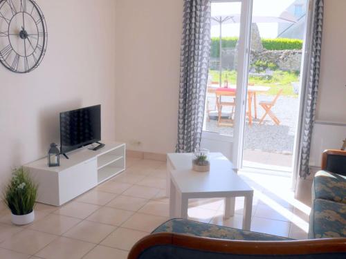 un salon avec une télévision et une table dans l'établissement Holiday Home in Guissény near Beaches, à Guissény