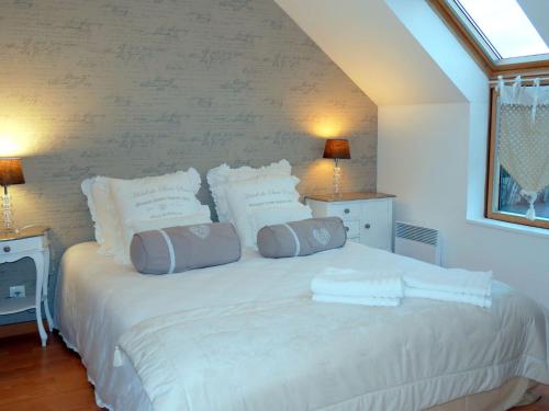 a bedroom with a large white bed with pillows at Beachfront holiday home, Guisseny in Guissény