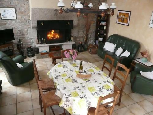 un salon avec une table et une cheminée dans l'établissement Holiday Home in Plouguerneau near Beach, à Guissény