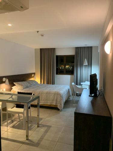 a hotel room with a bed and a desk at Beira-mar Hotel Ritz Suítes in Maceió