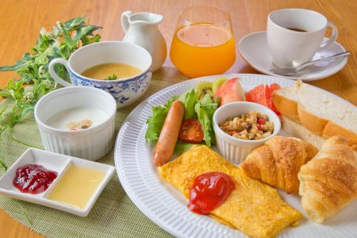 a table with a plate of breakfast foods and drinks at Ryokan Seifuso in Ōmuta