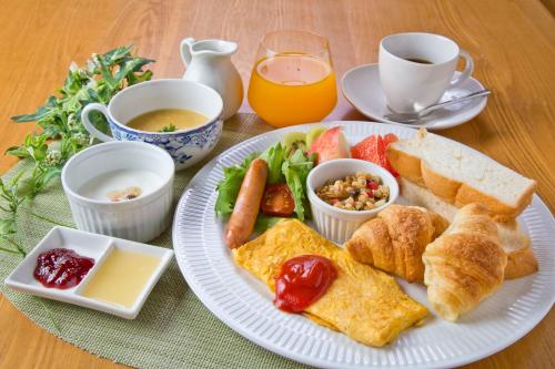 a plate of breakfast food with eggs bread and fruit at Ryokan Seifuso in Ōmuta