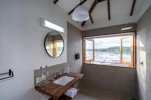 a bathroom with a sink and a mirror and a window at Indigo Blue Ceningan in Nusa Lembongan