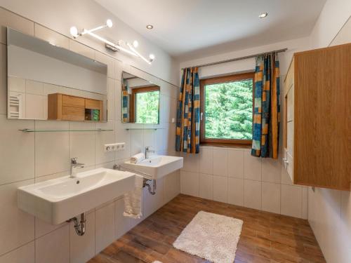 uma casa de banho com 2 lavatórios e uma janela em Hoellerhof Luxe em Radstadt