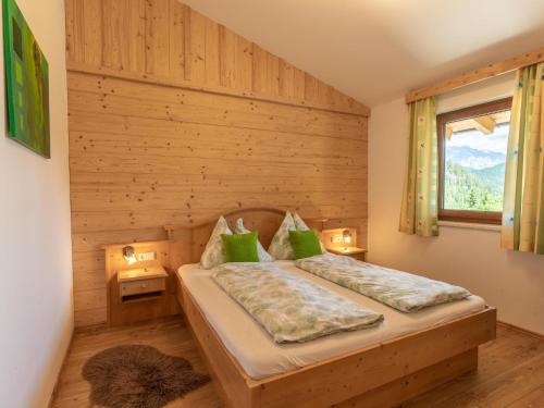 um quarto com uma cama e uma parede de madeira em Hoellerhof Luxe em Radstadt