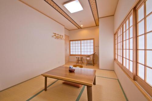 a room with a wooden table and windows at Ryokan Seifuso in Ōmuta