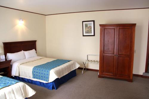 une chambre d'hôtel avec deux lits et une armoire dans l'établissement Hotel Tehuacan Plaza, à Tehuacán