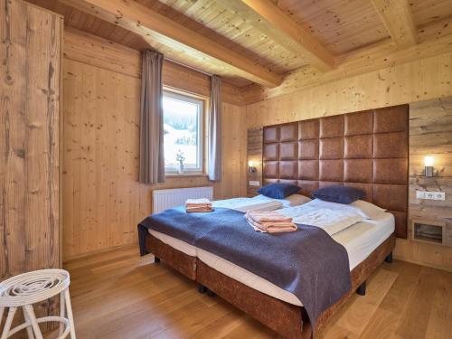 ein Schlafzimmer mit einem großen Bett in einem Holzzimmer in der Unterkunft Murtal Chalet in Sankt Michael im Lungau