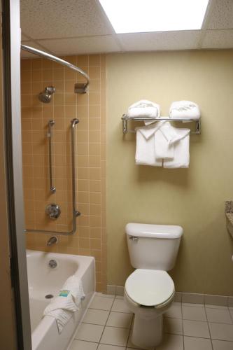 a bathroom with a toilet and a shower with towels at Bradley Inn in Windsor Locks